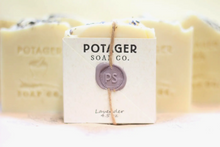 Load image into Gallery viewer, Potager Soap Co. handmade soap in the lavender scent. Label is held onto soap with a piece of twine and a melted wax seal.