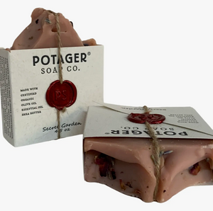 Potager Soap Co. handmade soap in the Secret Garden scent. Label is held onto soap with a piece of twine and a melted wax seal. Two bars shown, one standing and one laying on its side.