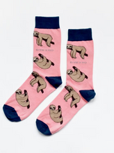 Load image into Gallery viewer, Pink socks with navy blue cuffs, heels and toes. Tan sloths on branches line the socks. The name Bare Kind is written in light grey under the first row of sloths.