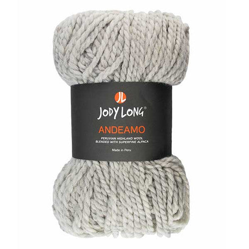 Bundle of light gray yarn on a white background. Thick strands of yarn held together in middle by black label that reads 