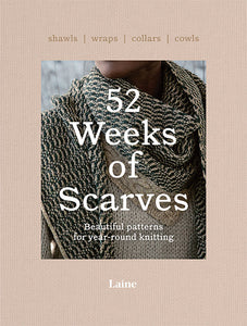 Light tan book titled "52 Weeks of Scarves" "Beautiful patterns for year-round knitting" underneath with "Laine" on bottom of book and "shawls, wraps, collars, cowls" on the top; image of person wearing black and tan knitted wrap over tan knitted sweater