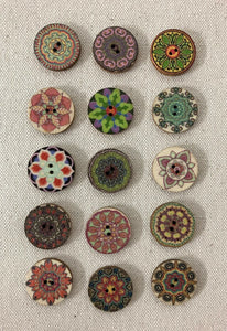 Image of several round and colorful mandala patterned buttons on light gray background. Each has two holes in middle