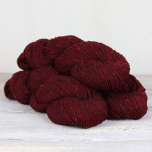 Load image into Gallery viewer, 3 red yarn skeins with flecks of pink, blue, and green throughout on white background.