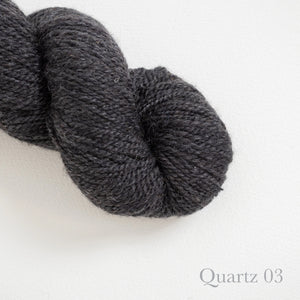 American Romney + Merino Yarn Stone Wool in color Quartz 03. Strands in shades of dark and light gray