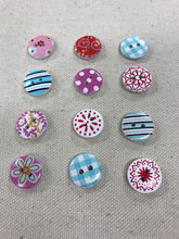 Load image into Gallery viewer, Image of several colorful round buttons with floral, stripe, and polka dot designs on them. Each has two holes in middle