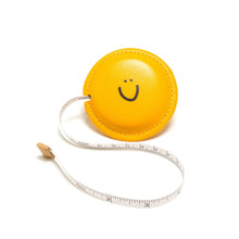 Load image into Gallery viewer, Yellow measuring tape with a smiley face on a white background