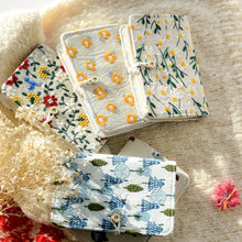 Load image into Gallery viewer, Three floral-patterned fabric wallets on a textured surface.