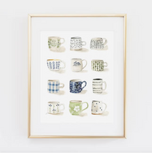 Load image into Gallery viewer, Gold colored frame around white print with mugs in four lines of three along it on white background. Mugs are various shades of blue, green and gray and feature images of flowers, polka dots, trees, etc.