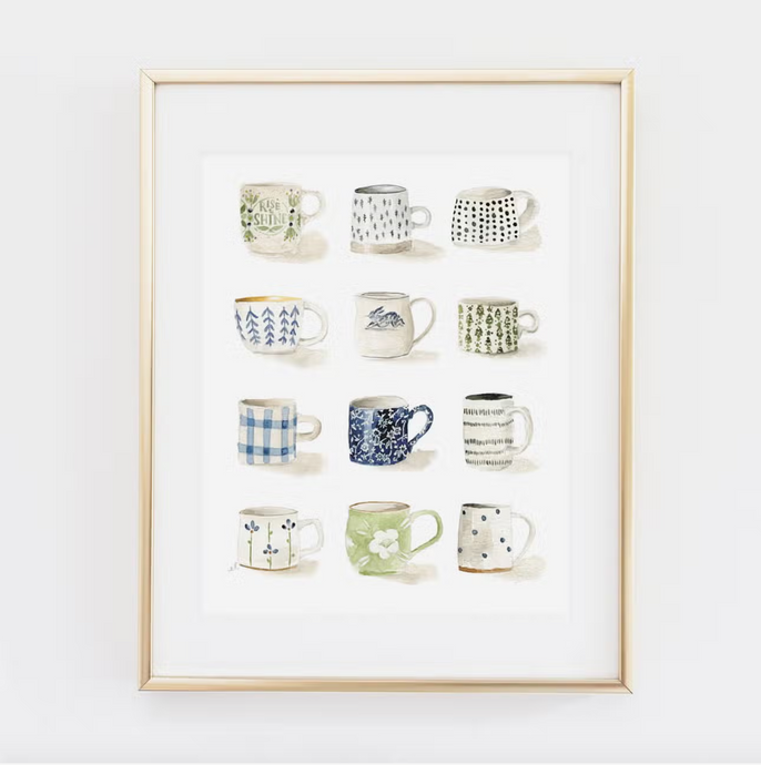 Gold colored frame around white print with mugs in four lines of three along it on white background. Mugs are various shades of blue, green and gray and feature images of flowers, polka dots, trees, etc.