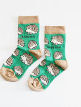 Load image into Gallery viewer, Green socks with tan cuffs, heels and toes. Tan and beige hedgehogs line the socks. The name Bare Kind is written in black under the first row of hedgehogs.