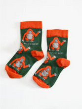 Load image into Gallery viewer, Forest green socks with deep orange cuffs, heels and toes. Deep orange orangutans with light grey faces, bellies, and hands line the socks. The name Bare Kind is written in light grey under the first row of orangutans.