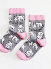 Load image into Gallery viewer, Light grey socks with baby pink cuffs, heels and toes. White rabbits, some sleeping, line the socks. The name Bare Kind is written in black under the first row of rabbits.