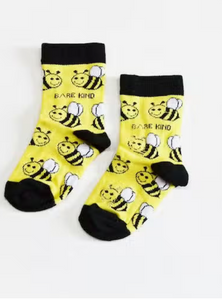 Yellow socks with black cuffs, heels and toes. Yellow and black bees with white wings line the socks. The name Bare Kind is written in black under the first row of bees.