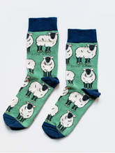 Load image into Gallery viewer, Light teal green socks with navy blue cuffs, heels and toes. White sheep with dark grey faces and legs line the socks. The name Bare Kind is written in dark grey under the first row of sheep. 