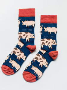 Navy blue socks with red cuffs, heels and toes. Alternating rows of plain pink pigs and pink pigs with brown spots line the socks. The name Bare Kind is written in light blue under the first row of pigs. 