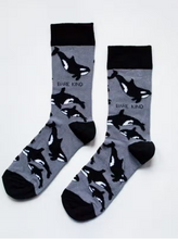 Load image into Gallery viewer, Grey socks with black cuffs, heels and toes. Black and white whales line the socks. The name Bare Kind is written in black under the first row of whales. 