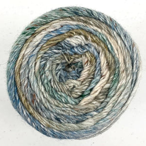 Close up of Noro yarn in color Hamura; Strands in shades of blue, green, and brown spiral in circle on white background