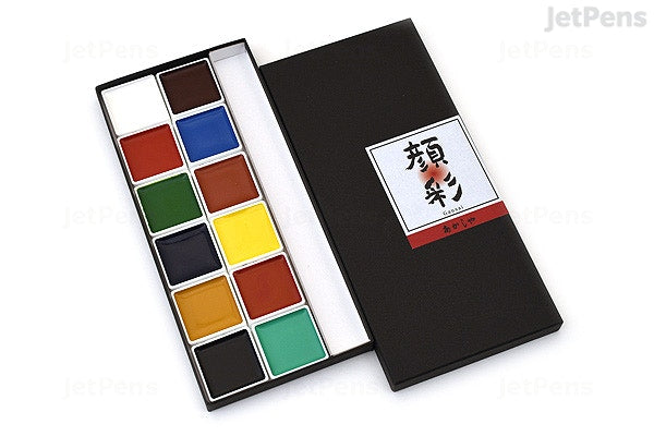 Black paint pallete case opened up on white background to reveal 12 color squares; Top of pallette case in white square reads 