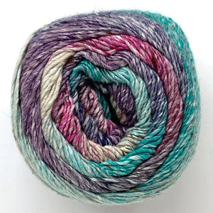 Close up of top of Noro yarn in color Shiroishi; Strands in shades of pink, blue purple, and tan spiral in circle on white background