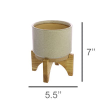Load image into Gallery viewer, One HomArt Ames Cachepot in light gray with dark speckles throughout sitting on wooden stand against white background. Line below indicates to measure 5.5&quot; across and line to right indicates it measures 7&quot; tall