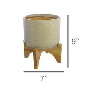 One HomArt Ames Cachepot in light gray with dark speckles throughout sitting on wooden stand against white background. Line running across bottom indicates it measures 7" across and line running along right indicates it measures 9" tall