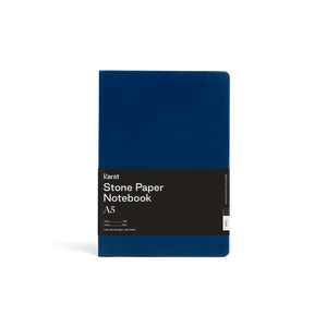 Soft dark blue journal; Large black rectangular paper wrap half way down reads "KARST" "Stone paper Notebook "A5" on right side; Small "K" in right side bottom corner of cover