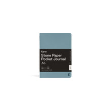 Load image into Gallery viewer, Small light blue journal on white background with black paper wrap covering middle section; Black wrap reads &quot;KARST&quot; &quot;Stone Paper Pocket Journal&quot; &quot;A6&quot; in white on right side; Small blue &quot;K&quot; stamped in bottom right corner of cover