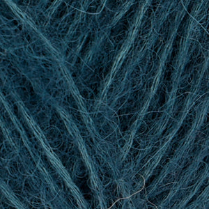Close up of Rowan Alpaca Classic yarn in color 109. Strands in shades of light and dark blue
