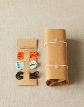Load image into Gallery viewer, Image of cardboard slip holding 3 elastic bands and accessory roll on light tan background; Band colors from top to bottom of slip are orange, light blue, and black; Accessory roll to right of cardboard slip wrapped in white bands