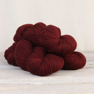 The Fibre Co. Amble yarn in color Appleby Castle. Strands in shades of red