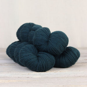 The Fibre Co. Amble yarn in color Eden Valley. Strands in shades of dark blue