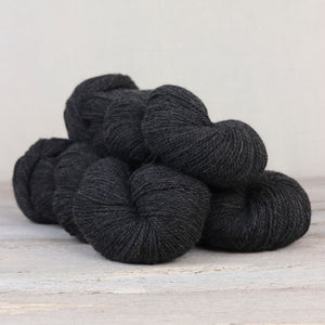 The Fibre Co. Amble yarn in color Saddleback Slate. Strands in shades of dark gray
