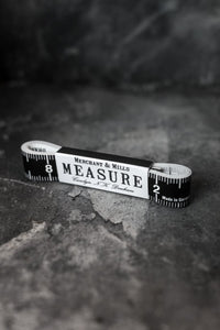 Black and white tape measurer wound up and secured in black and white Merchant & Mills label