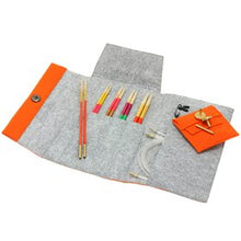 Load image into Gallery viewer, Open gray project pouch on white background with knitting needles sticking out of middle front pocket, small orange pouch sitting on right side and long strip of orange with snap button on lefts side