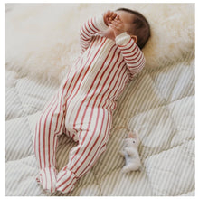 Load image into Gallery viewer, Baby in red and white striped sleeper lays on white background next to ornament of a white bunny
