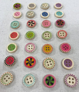 Image of several round and colorful buttons on light gray background. Each have four holes in middle