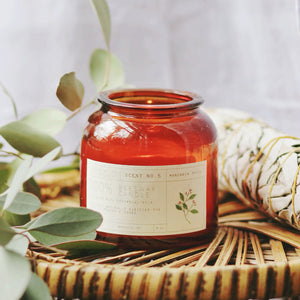 Mandarin Spice scented candle. Red/orange glass bottle with a cork top, white label with black lettering.