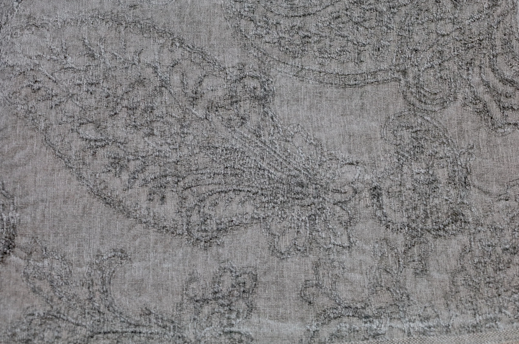 Close up on dark gray throw with floral detailing throughout