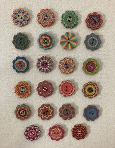 Image of several colorful buttons in floral shapes on tan background. Each have two holes in middle